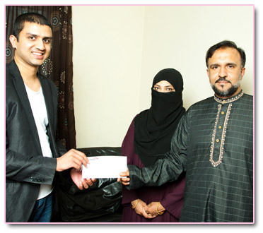 Adeem Younis presents Mohammad and Anila with Umrah Tickets.