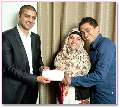 Adeem Younis presents Nanu and Rumana with Umrah tickets.